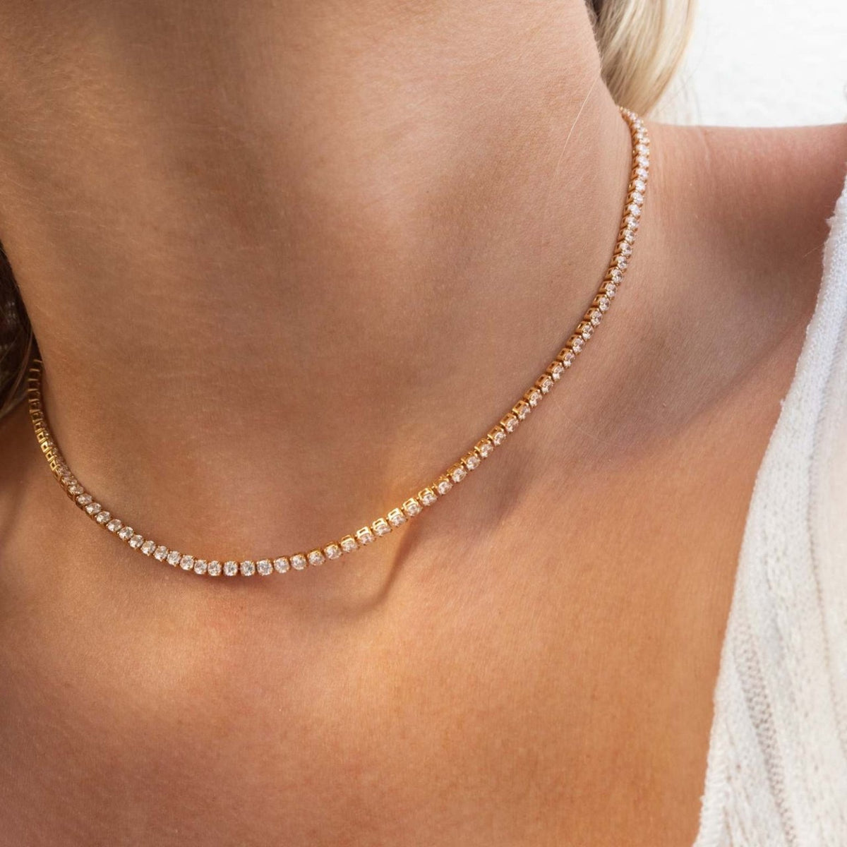 Close-up of a gold necklace on a person's neck